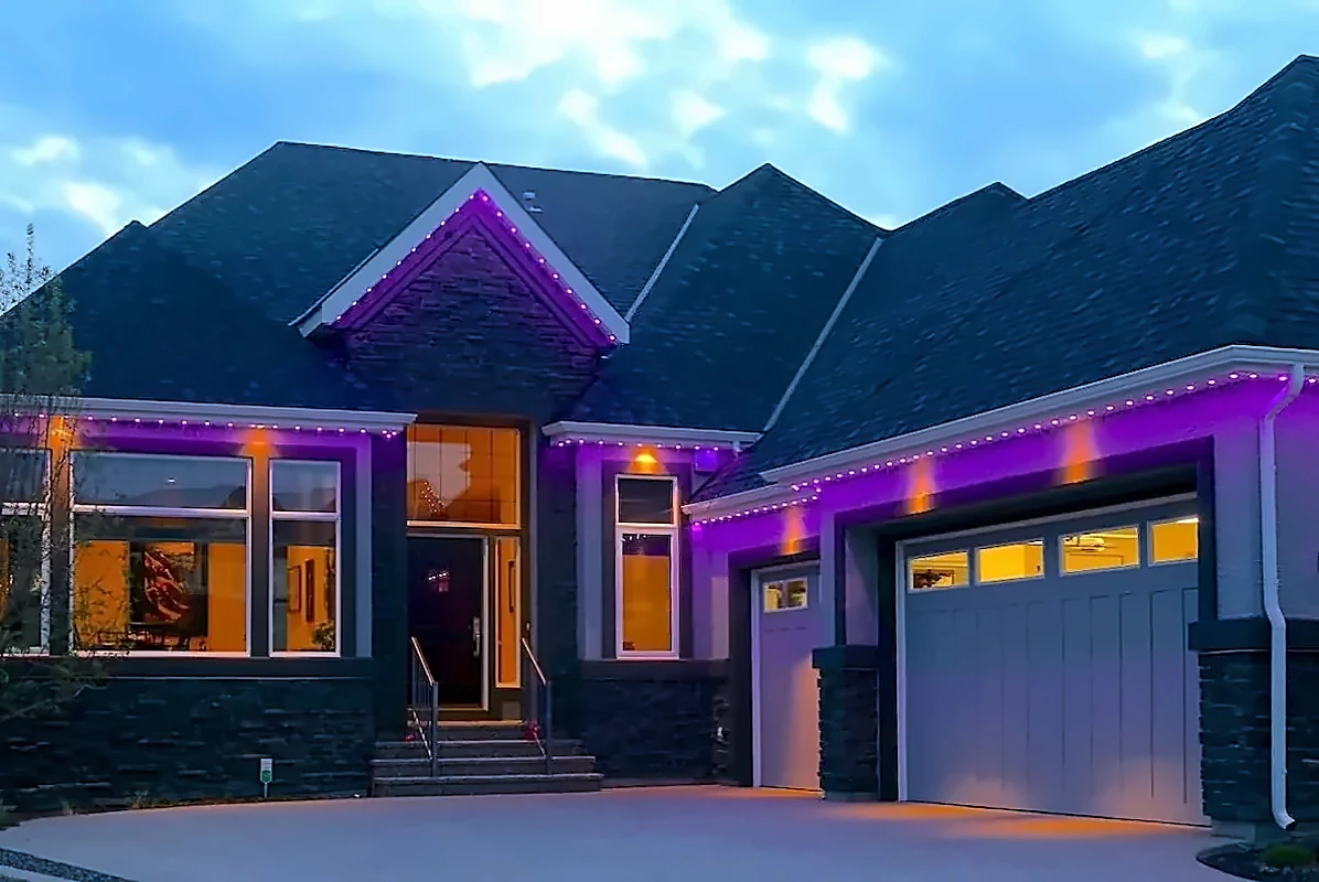 Modern home at dusk with permanent roofline lighting set to purple